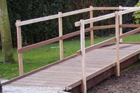 De houten trap heeft aan de zijkanten een houten lat als afrijdbeveiliging.
