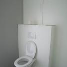 Een aangepast toilet wordt optimaal ook uitgerust met beugels. Aangezien de voorzetwand vrij breed is, was het beter als er ook een verlengde toiletpot voorzien was. (Chiro St-Jan Kachtem)