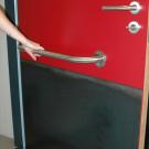De deur van het aangepast toilet draait steeds naar buiten open. Op de binnenzijde van de deur wordt een horizontale beugel bevestigd. Dit vergemakkelijkt het dichttrekken van de deur. (Jeugdhuis Rondpunt 26, Genk)